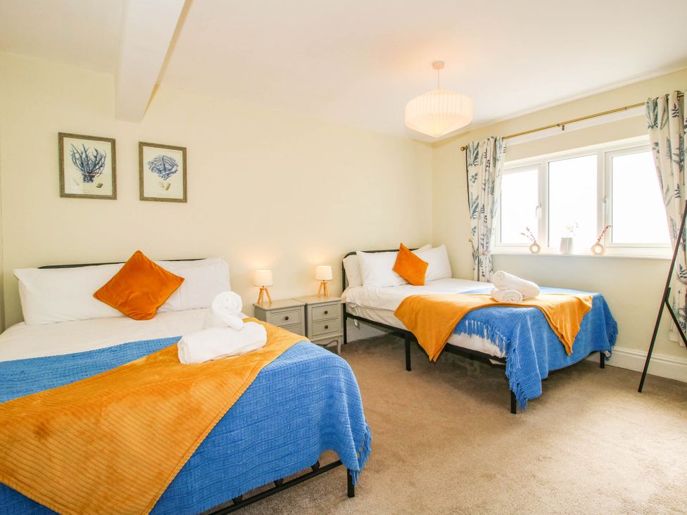 A bedroom with two beds and bedside tables at The Lodge in Shawbury