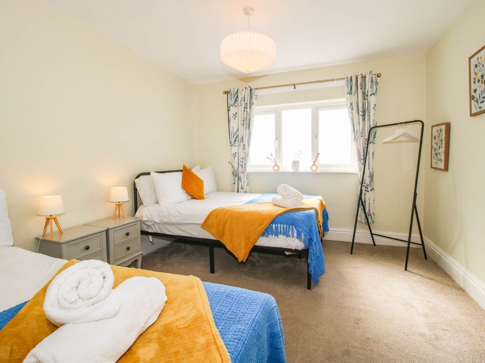 A bedroom with two beds and a table at The Lodge in Shawbury