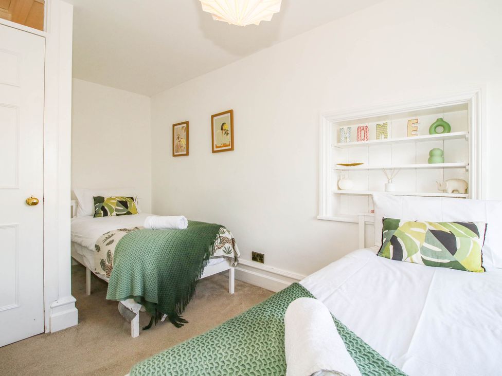 A bedroom with two beds and decorative items on a shelf at The Lodge in Shawbury