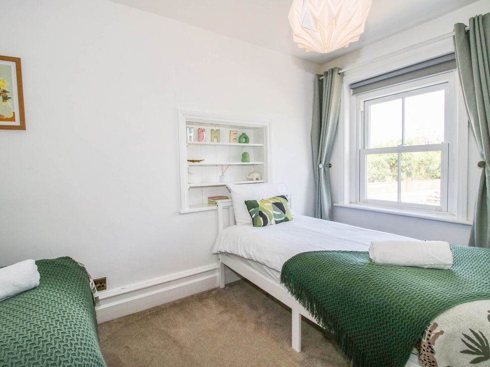 A bedroom with two single beds and a shelf at The Lodge in Shawbury