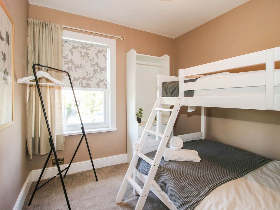 A bedroom with a bunk bed and clothes rack at The Lodge in Shawbury
