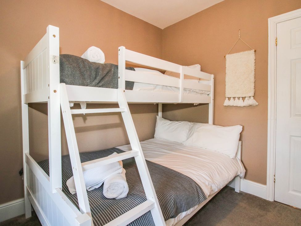 A bunk bed and single bed in a bedroom at The Lodge in Shawbury