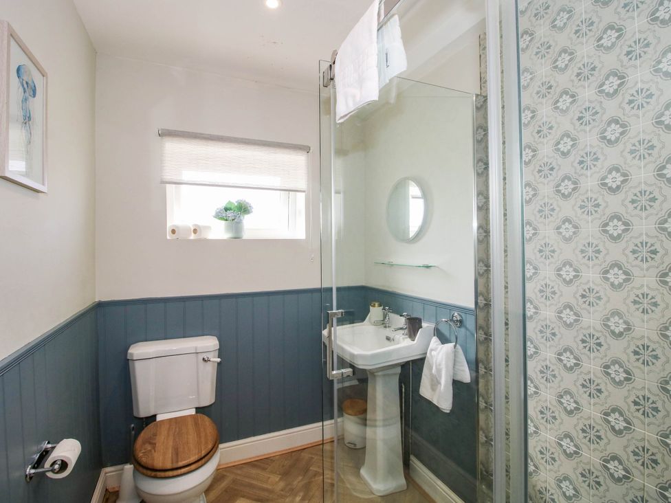 A bathroom featuring a toilet, sink, shower and mirror at The Lodge in Shawbury