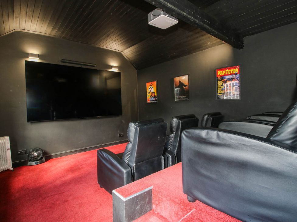 A home theater with a screen and seating at The Lodge in Shawbury