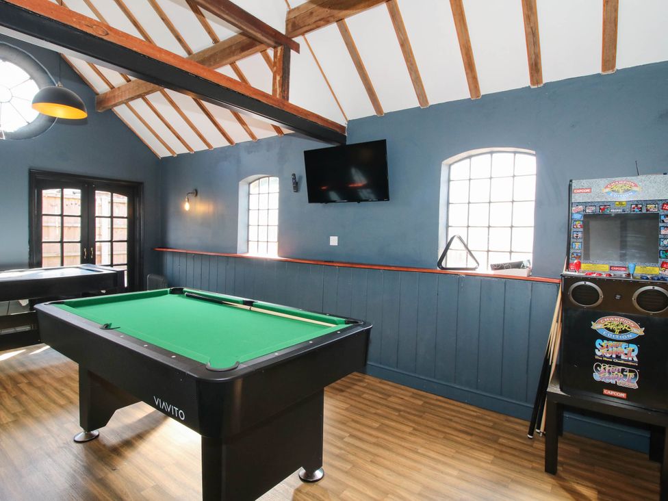 A game room with a pool table and arcade machine at The Lodge in Shawbury