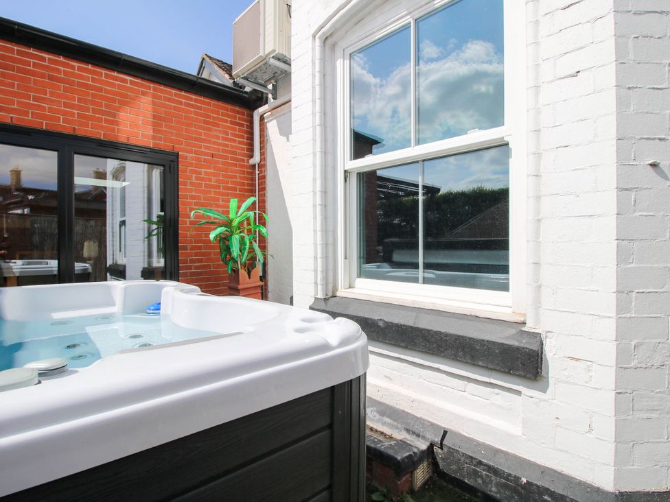 An outdoor area with a hot tub and a window at The Lodge in Shawbury