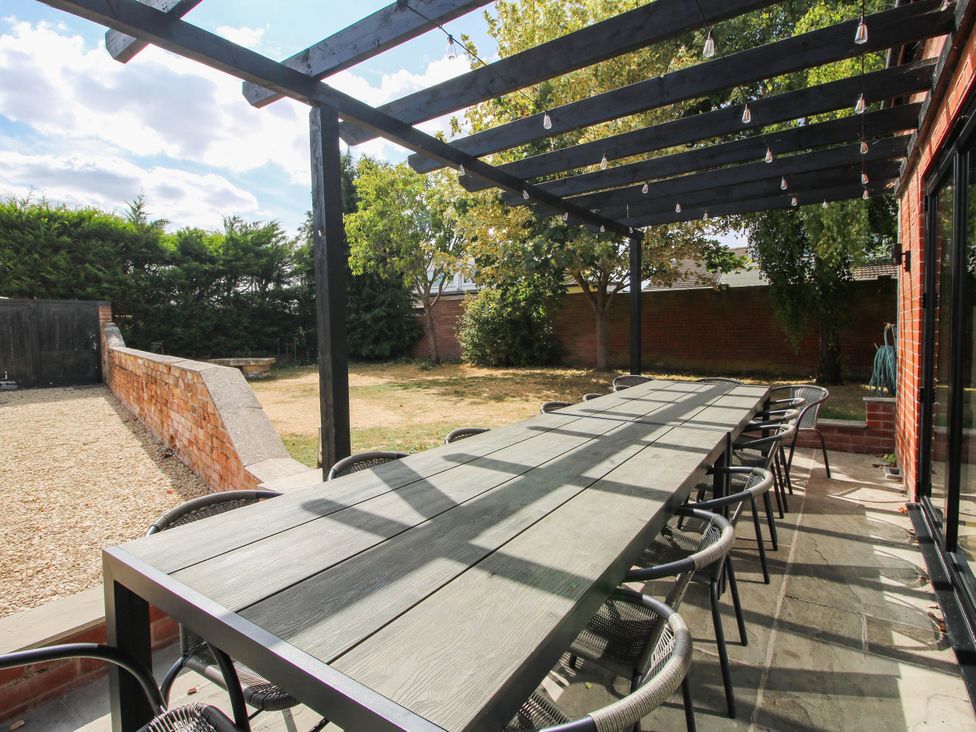 A garden with a table and chairs under a pergola at The Lodge in Shawbury