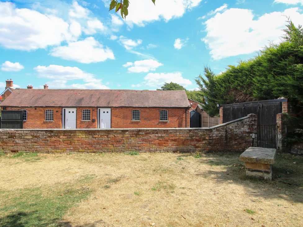 An outdoor area with a brick wall and doors at The Lodge in Shawbury