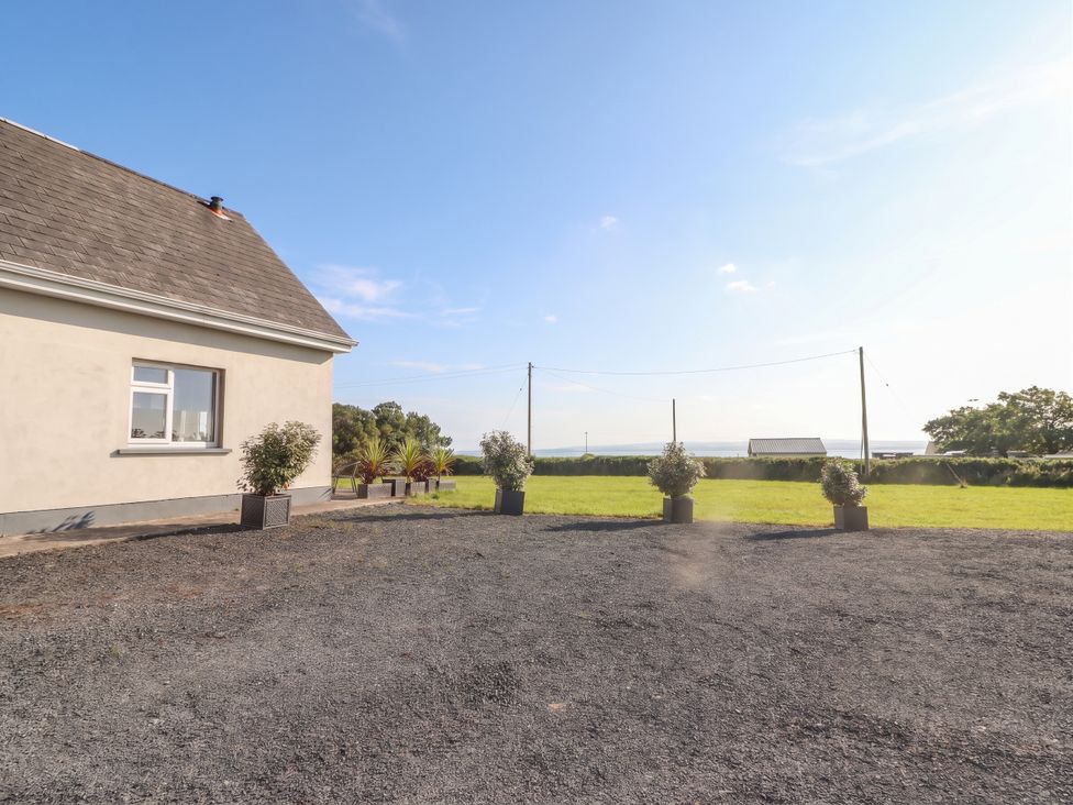 An outdoor area with a house and planters at The Boathouse in Carrigaholt, County Clare