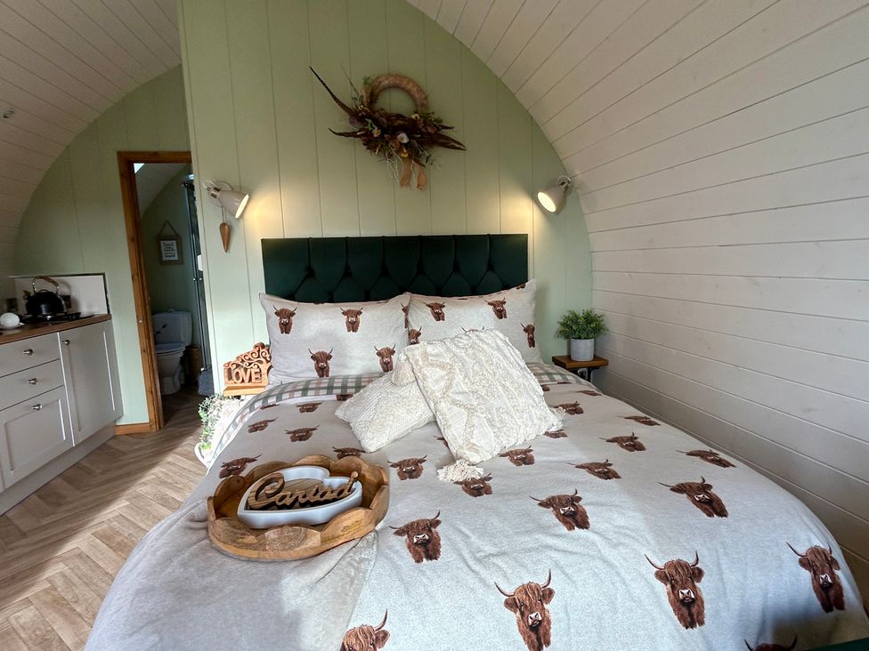 A bedroom with a bed, kitchenette and door to a bathroom at Willow in Llangurig near Llanidloes