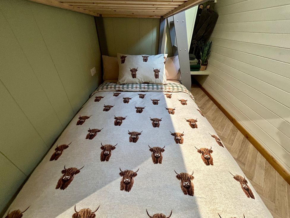 A bed with patterned bedding in a bedroom at Willow in Llangurig near Llanidloes