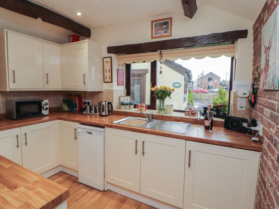 A kitchen with cabinets and appliances at River Cottage in Eamont Bridge