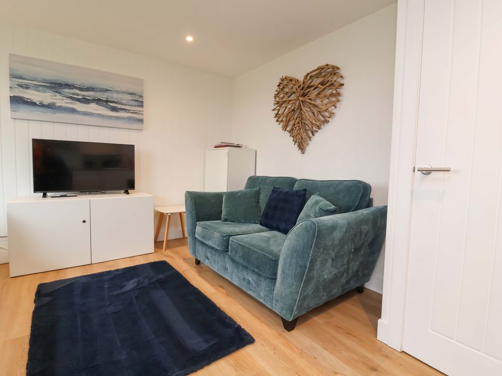 A living room with a sofa and television at Cassia in Kilkhampton