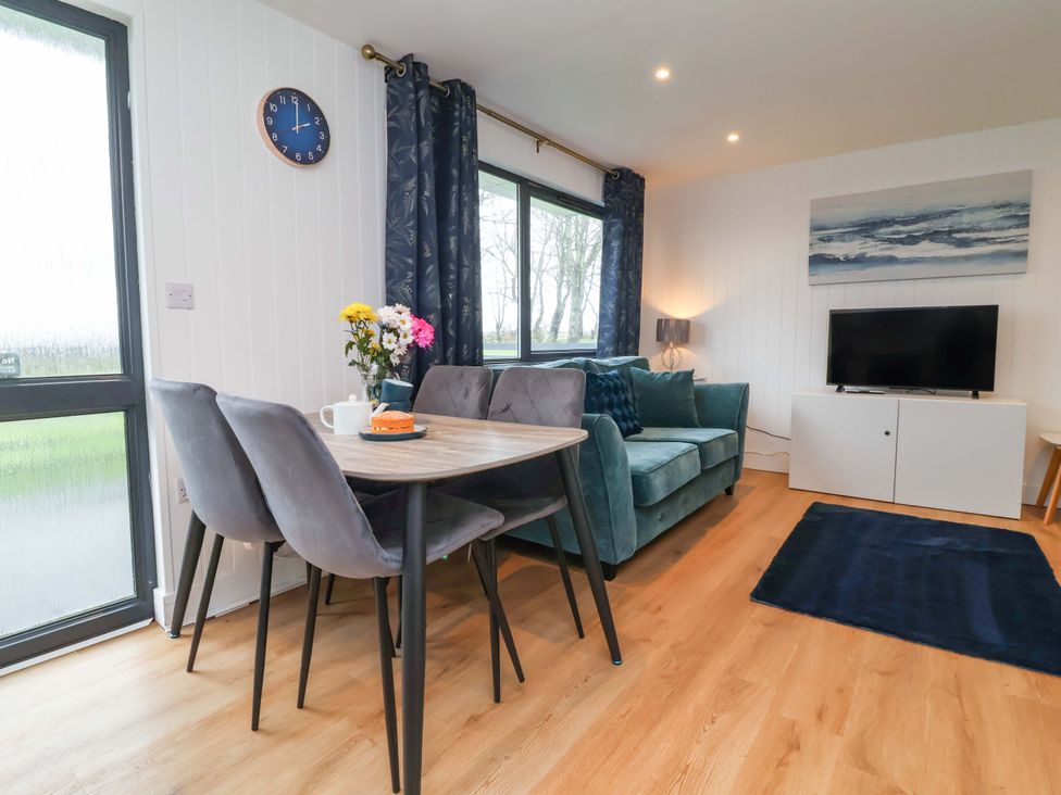 A living room with a dining table and sofa at Cassia in Kilkhampton