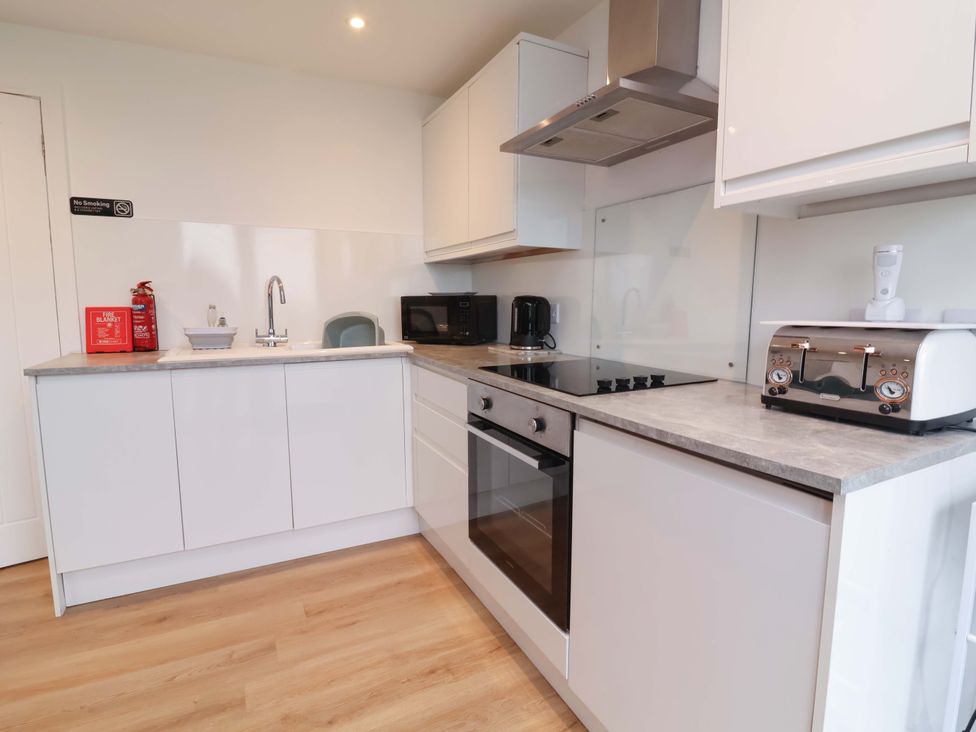 A kitchen with appliances and a fire extinguisher at Cassia in Kilkhampton
