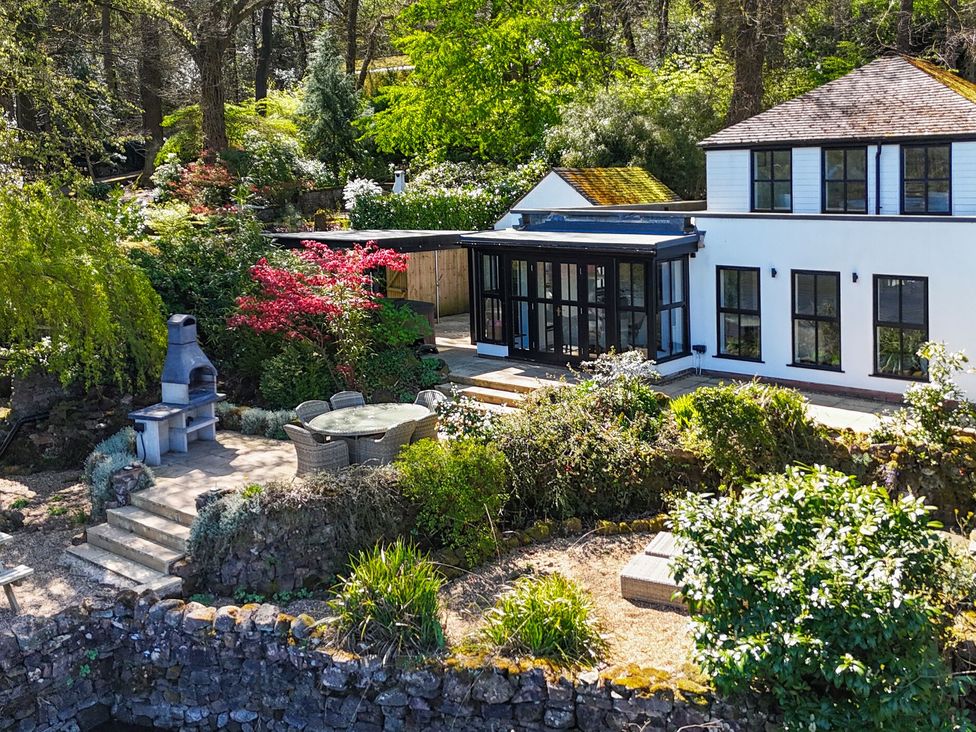 An outdoor patio with garden furniture and fireplace at The Sheiling in Rudyard Lake