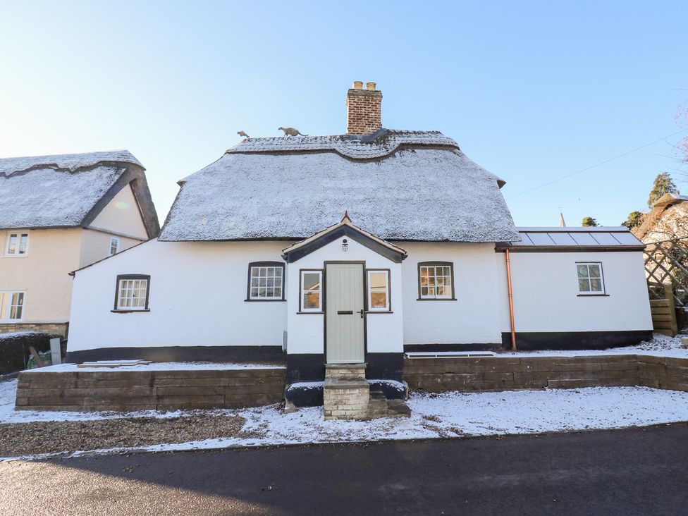 A cottage with a thatched roof and front door at 66 High Street in Cambridge