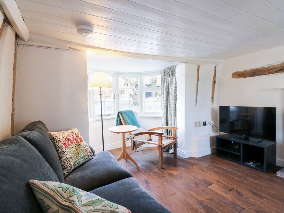 A living room with a sofa, chair, lamp, and television at 66 High Street, Cambridge