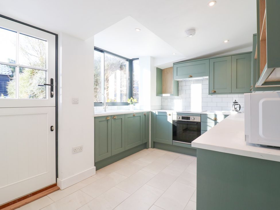 A kitchen with cabinets and appliances at 66 High Street in Cambridge