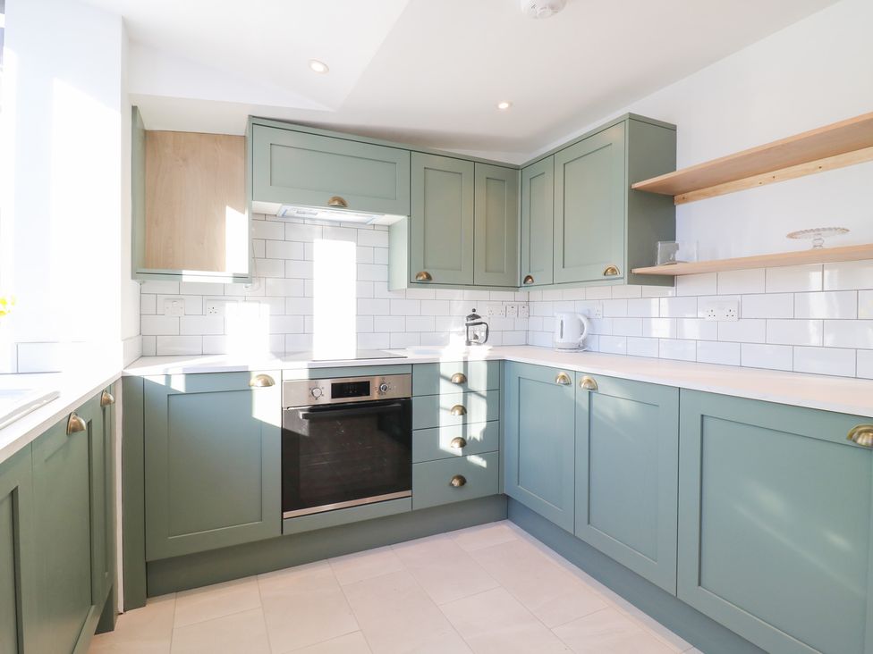 A kitchen with cabinets and appliances at 66 High Street in Cambridge