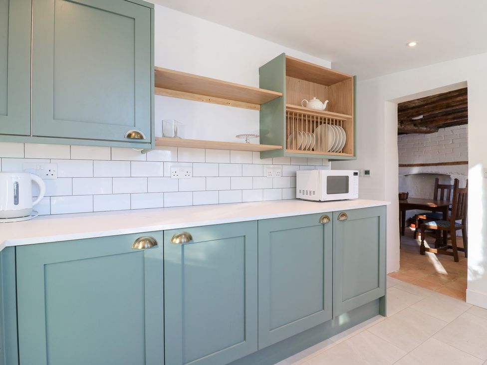A kitchen with cabinets, a microwave, and a kettle at 66 High Street, Cambridge