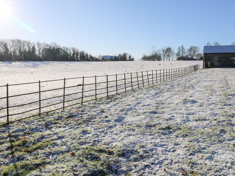 A field with a fence and a barn at 66 High Street in Cambridge
