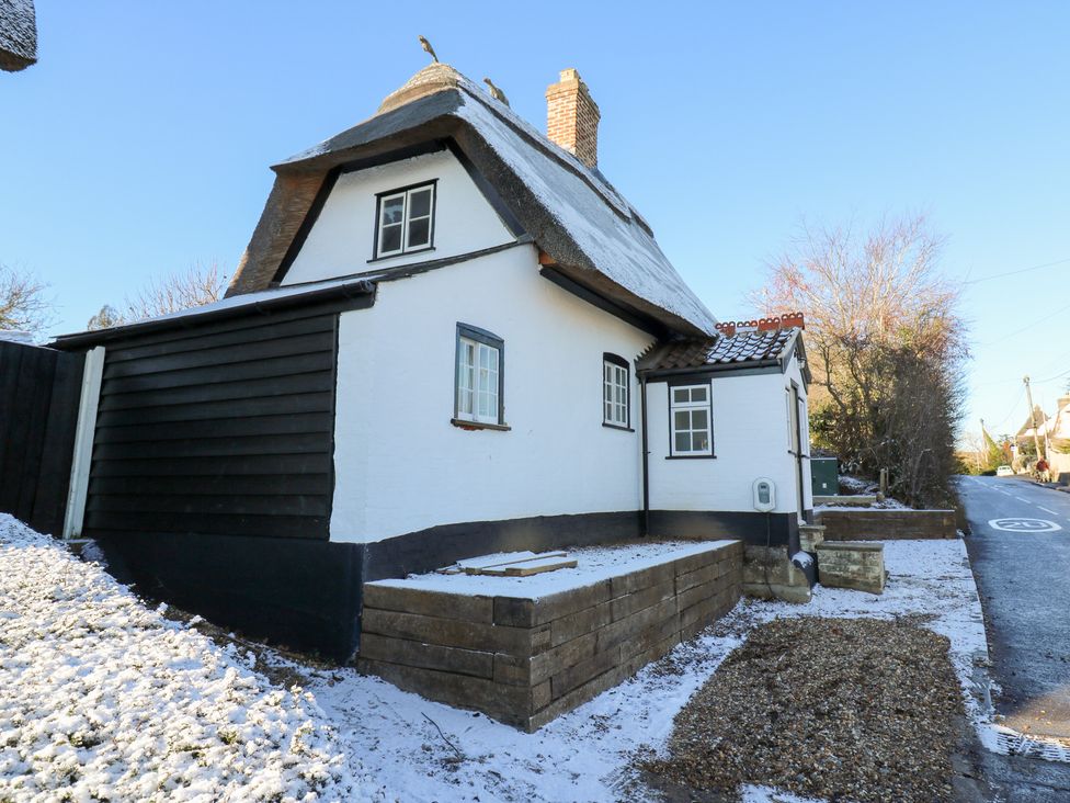 A house with a thatched roof in the snow at 66 High Street in Cambridge