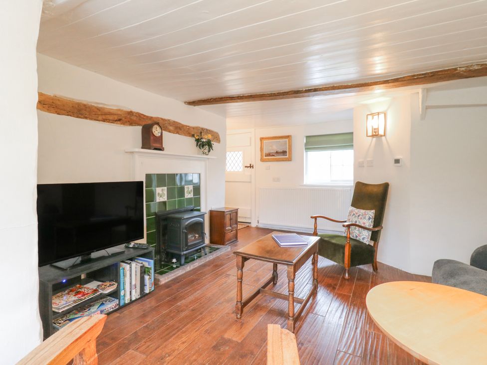 A living room with a television and fireplace at The Old Smithy in Bourn