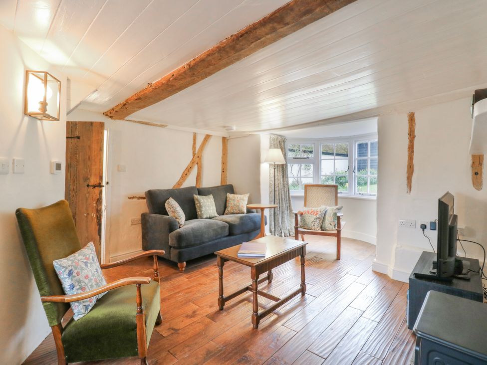 A living room with a sofa and armchairs at The Old Smithy in Bourn