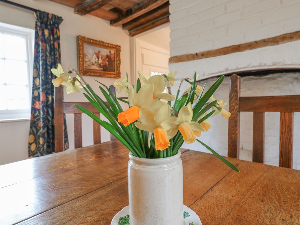 A dining room with flowers on the table at The Old Smithy in Bourn