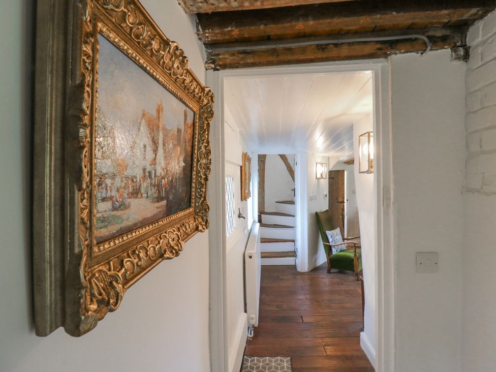 A hallway with a painting and stairs at The Old Smithy in Bourn