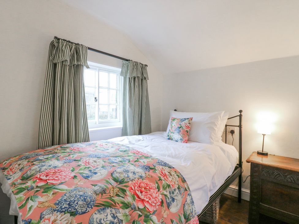 A bedroom with a bed and window at The Old Smithy in Bourn