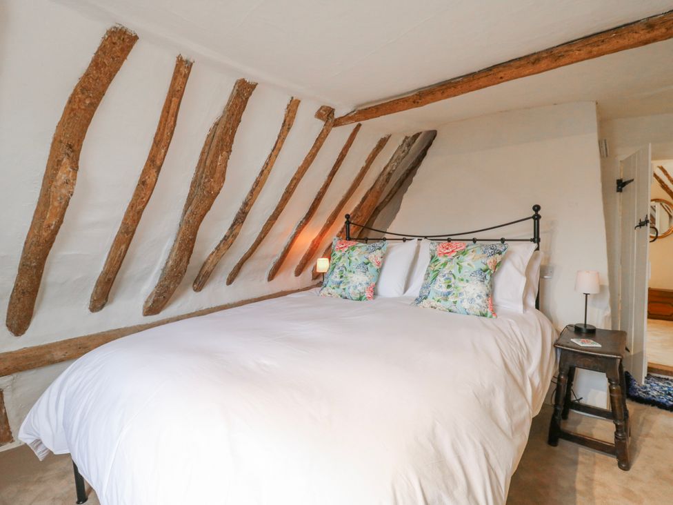 A bedroom with a bed and bedside lamp at The Old Smithy in Bourn