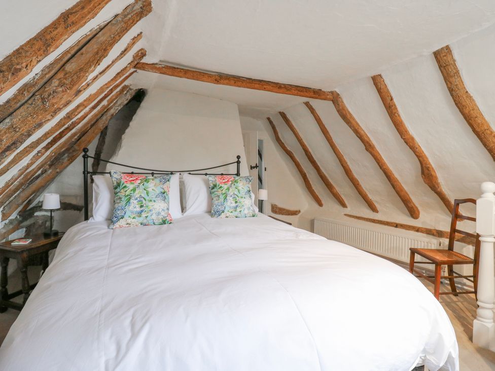 A bedroom with a bed and decorative pillows at The Old Smithy in Bourn