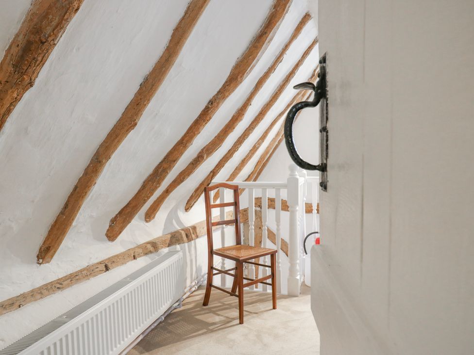 A landing with a chair and radiator at The Old Smithy in Bourn