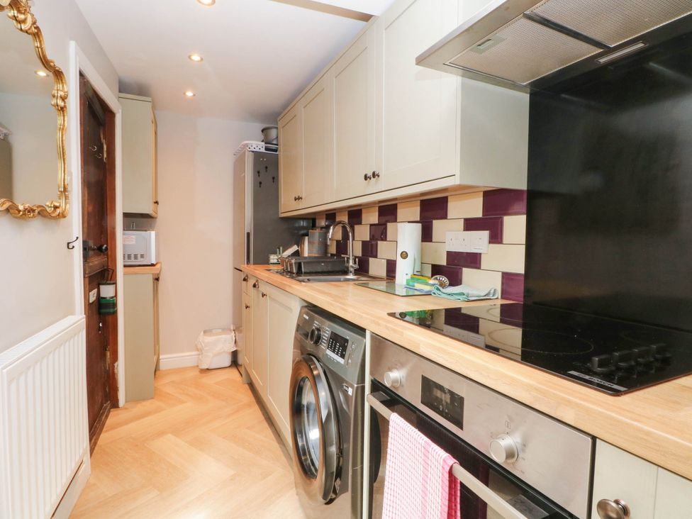 A kitchen with appliances and cabinetry at The Cottage O'ergate in Bradwell