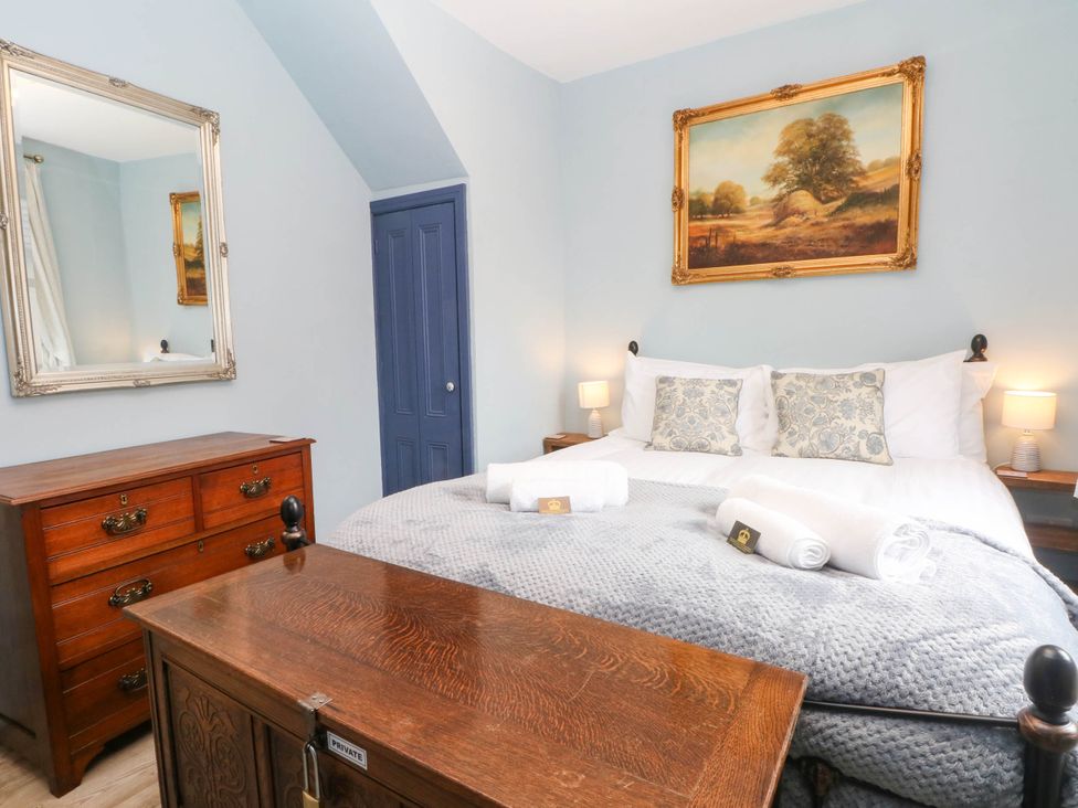 A bedroom with a bed and dresser at The Cottage O'ergate in Bradwell