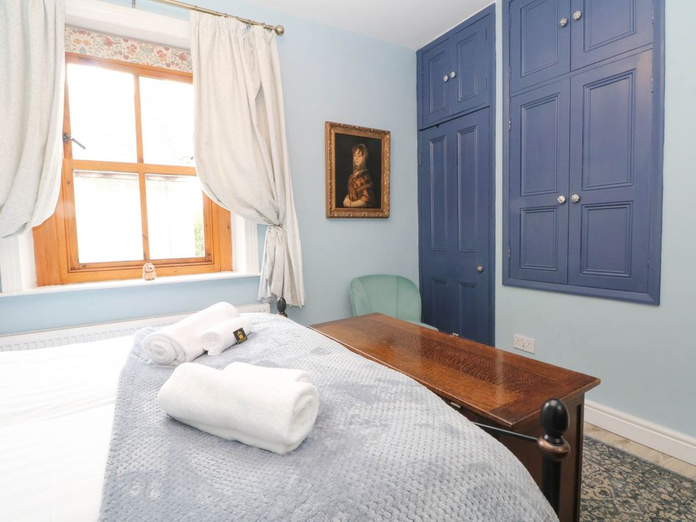 A bedroom with a bed, desk and window at The Cottage O'ergate in Bradwell