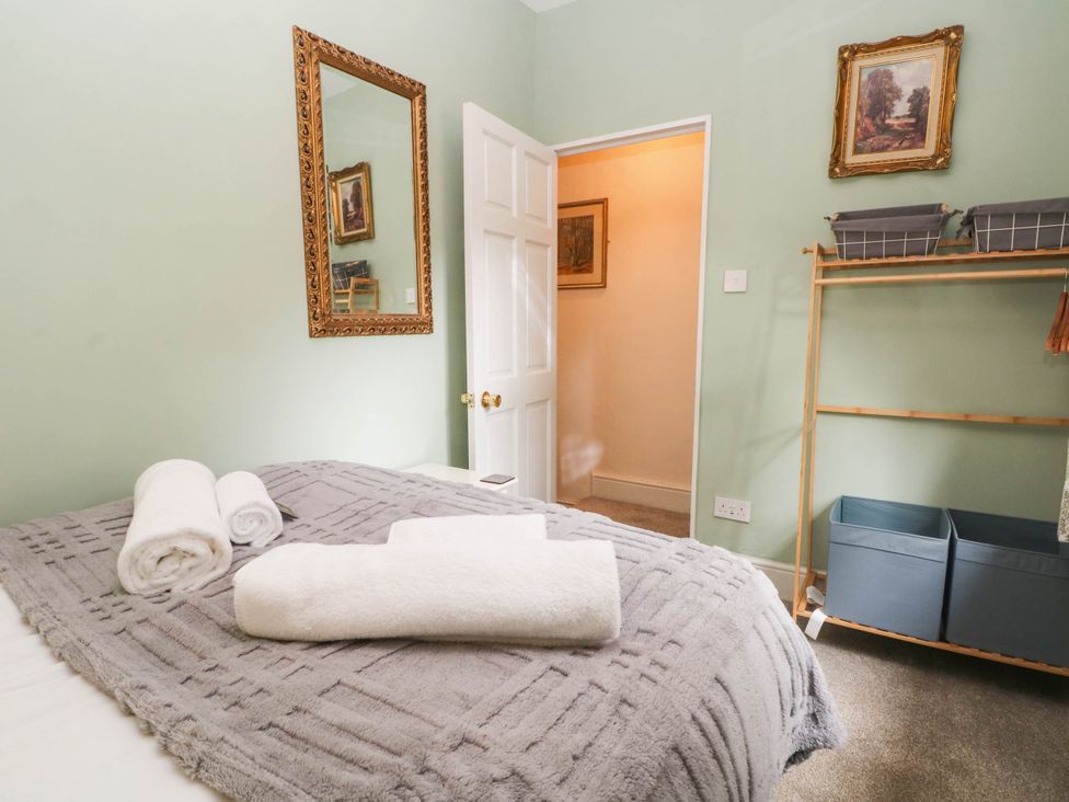 A bedroom with a bed and towels at The Cottage O'ergate in Bradwell