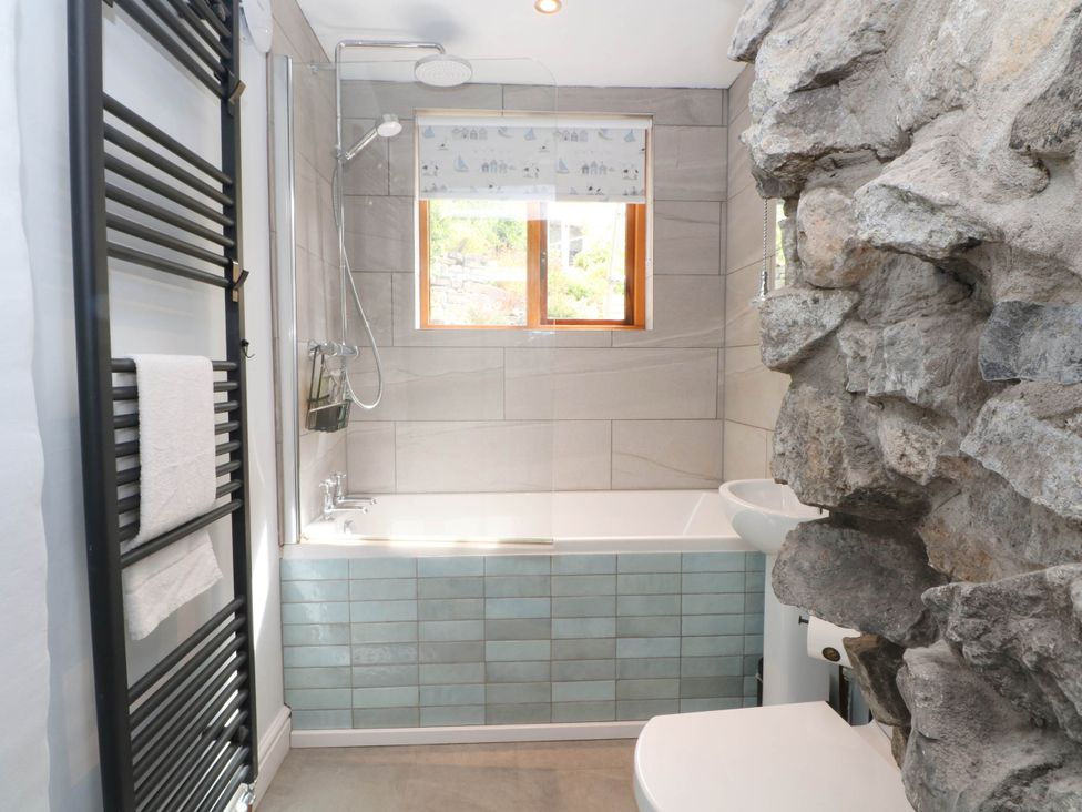 A bathroom with a bathtub and shower at The Cottage O'ergate in Bradwell