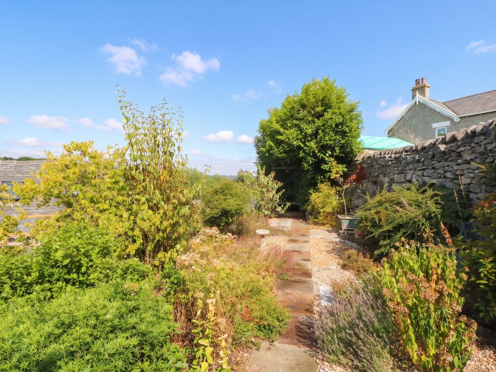 A garden with a pathway and various plants at The Cottage O'ergate in Bradwell