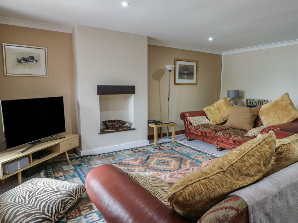 A living room with a television and sofa at Ty Haf in Trearddur Bay