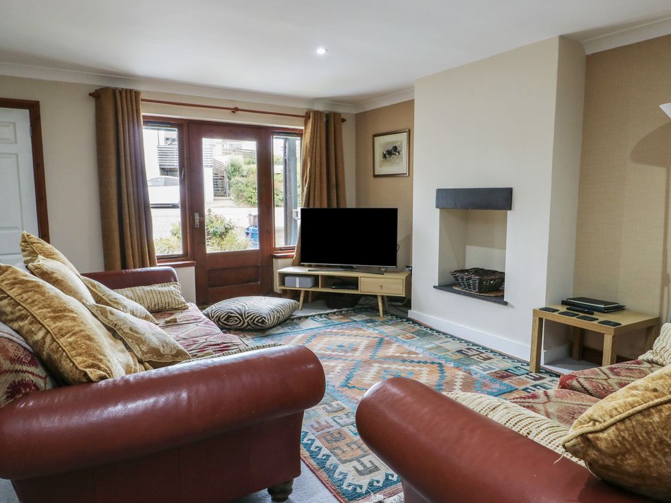 A living room with a sofa and television at Ty Haf in Trearddur Bay