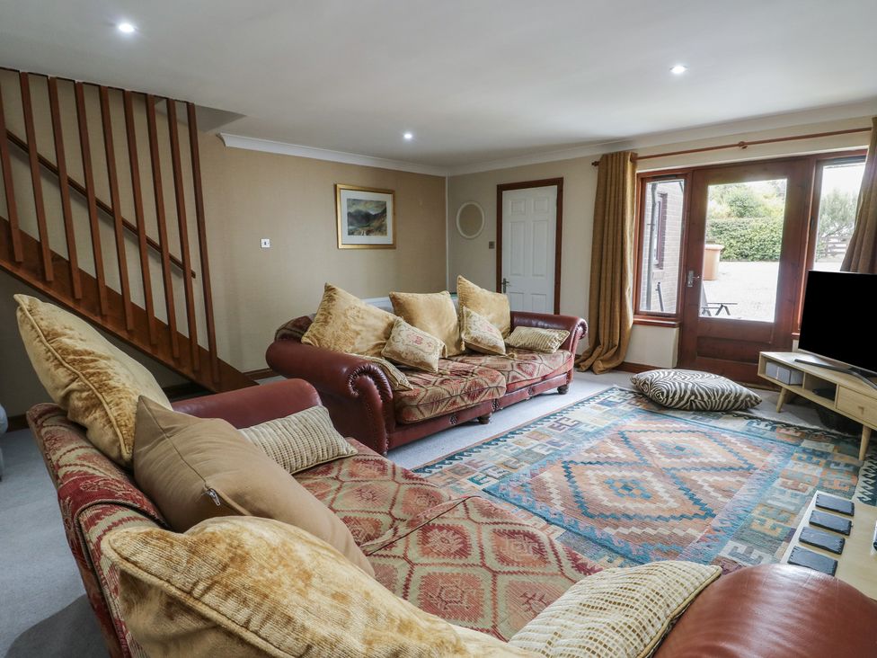 A living room with sofas and a large rug at Ty Haf in Trearddur Bay