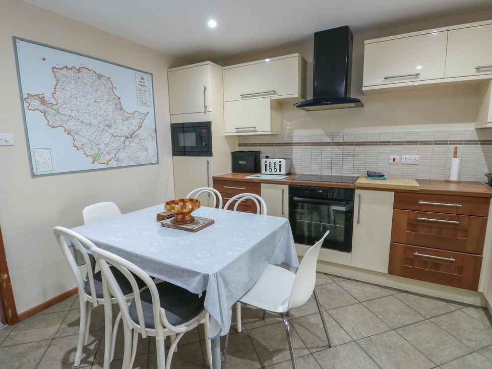 A kitchen with a table and chairs at Ty Haf in Trearddur Bay