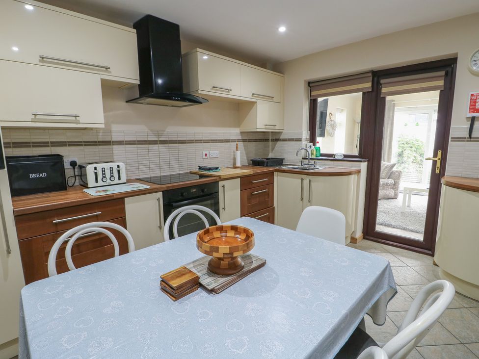 A kitchen with a table and chairs at Ty Haf in Trearddur Bay