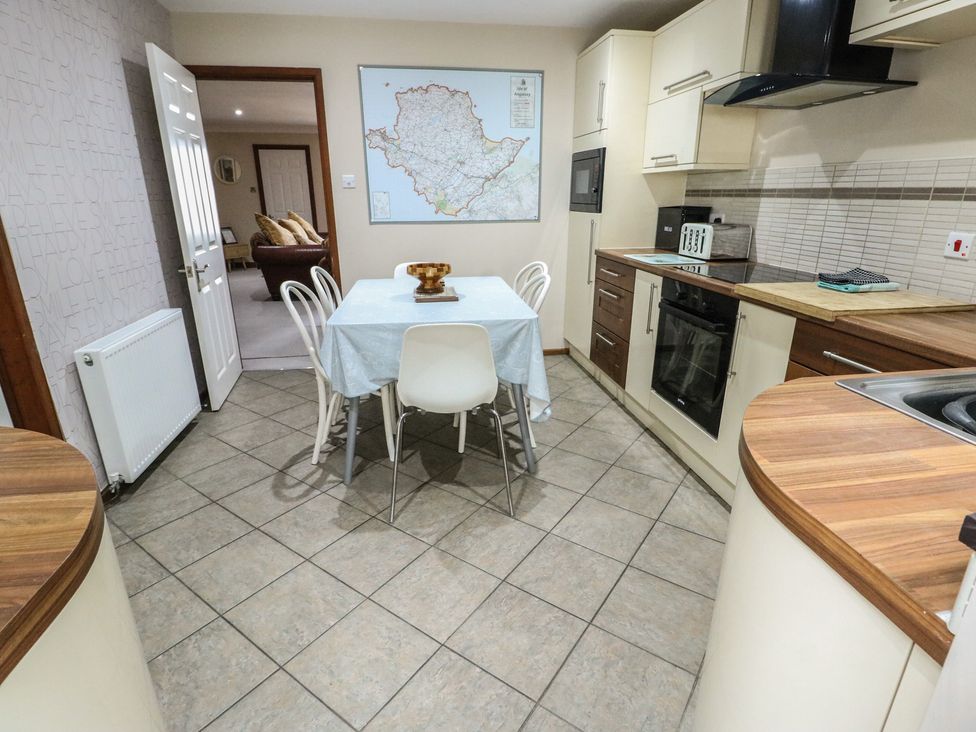 A kitchen with a table and chairs at Ty Haf in Trearddur Bay