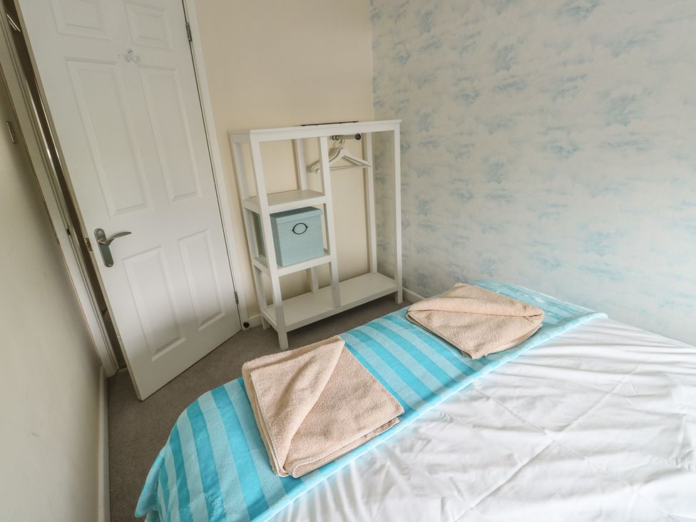 A bedroom with a bed and towels on it at Ty Haf in Trearddur Bay