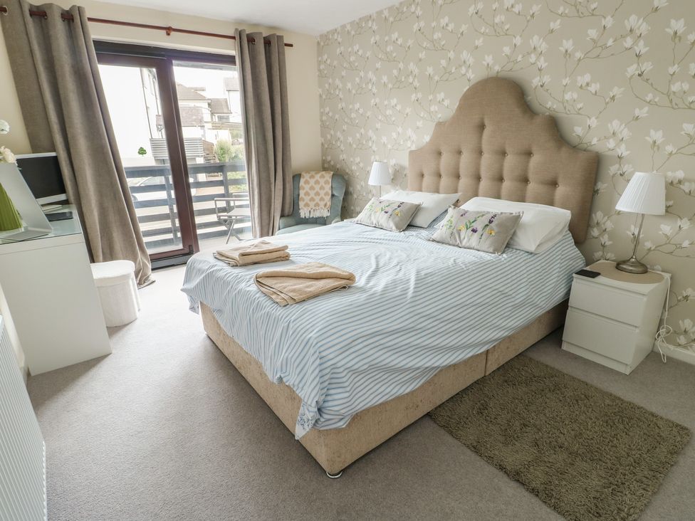 A bedroom with a double bed and bedside table at Ty Haf in Trearddur Bay
