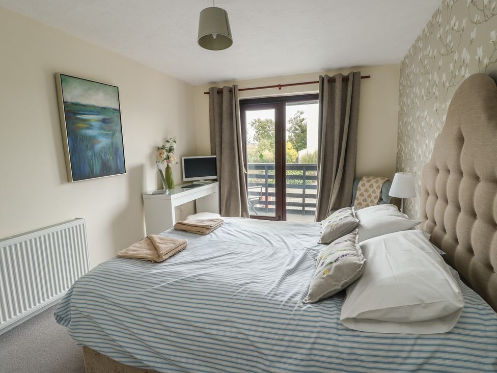 A bedroom with a bed and a television at Ty Haf in Trearddur Bay